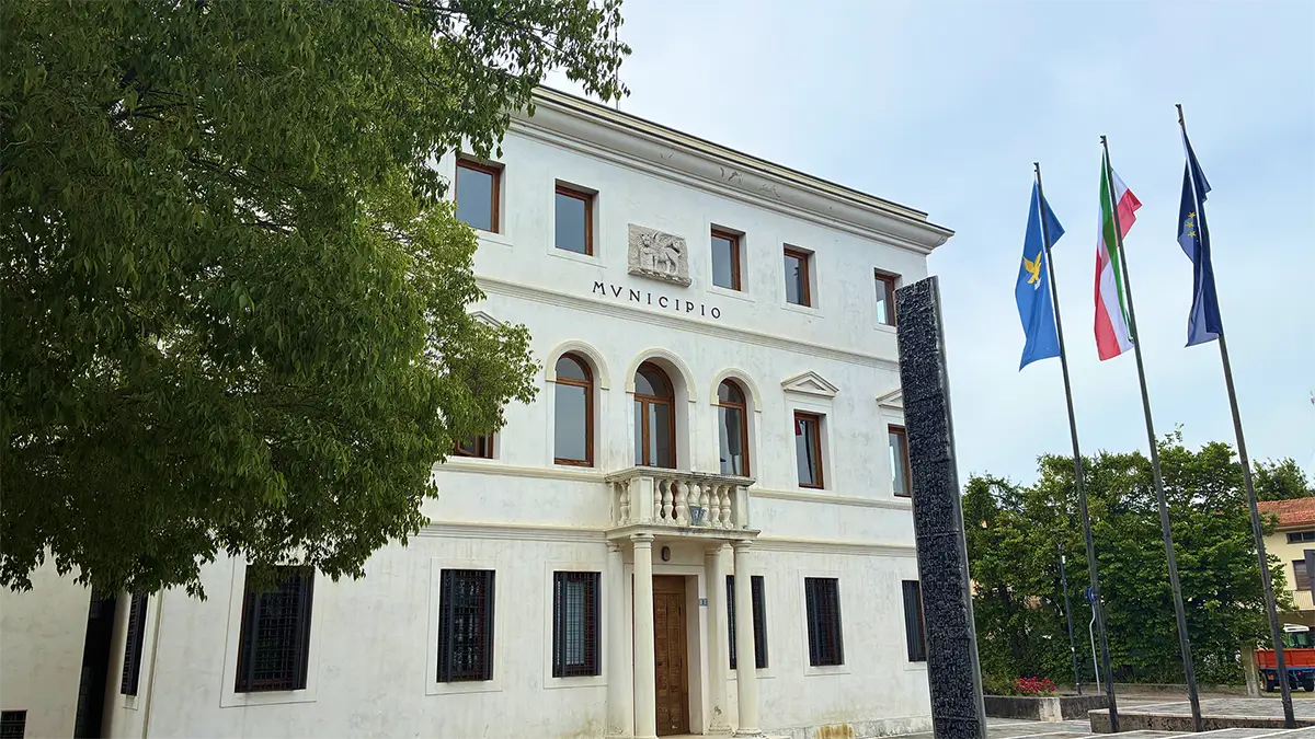 Facciata del municipio di Brugnera con bandiere istituzionali all’ingresso.