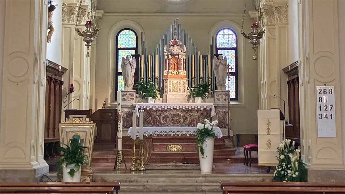 Interno di una chiesa a Brugnera con altare, vetrate e organo a canne.